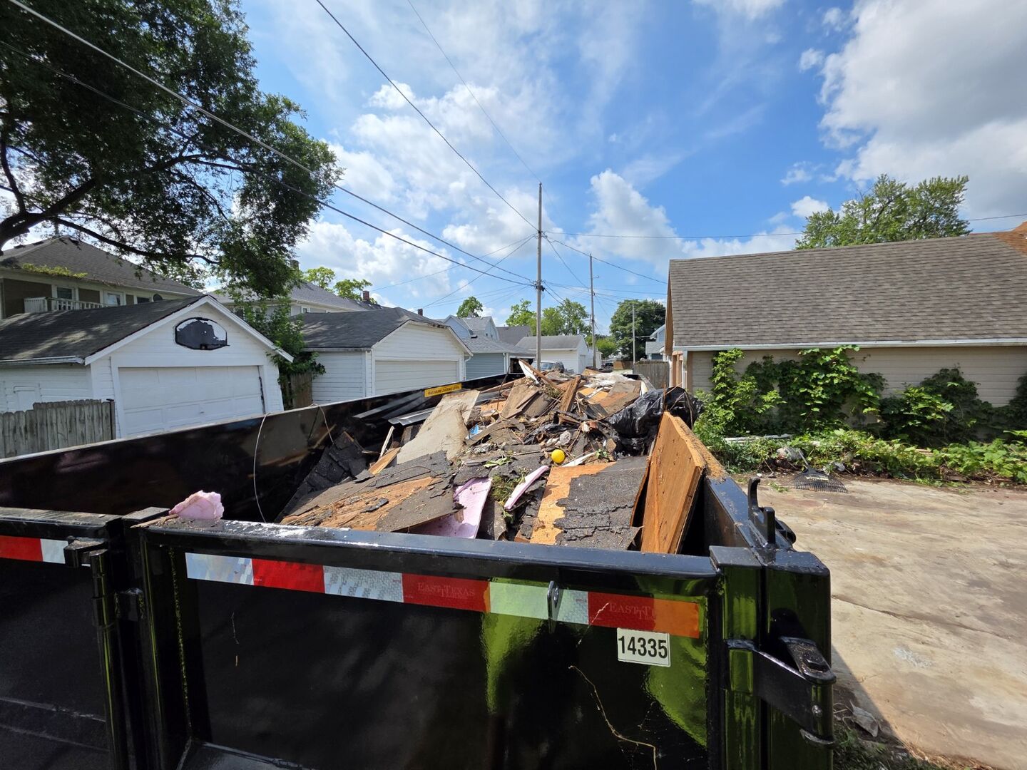 Demolition debris staged in a roll-off container