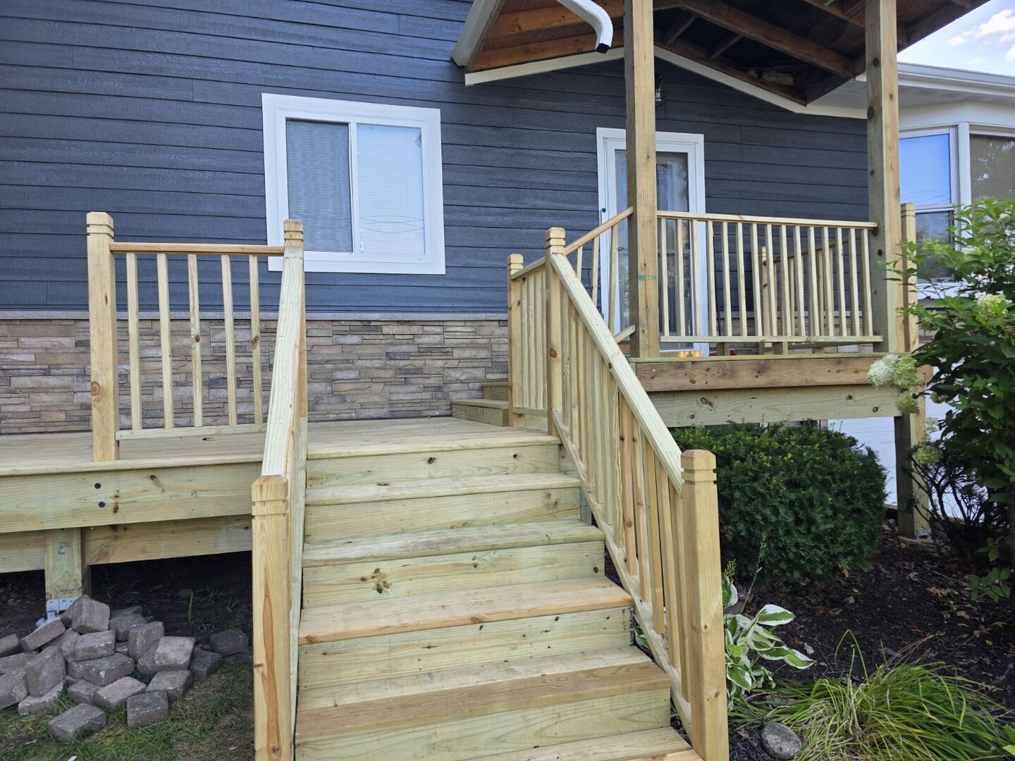 New wood deck stairway and railing leading to a home